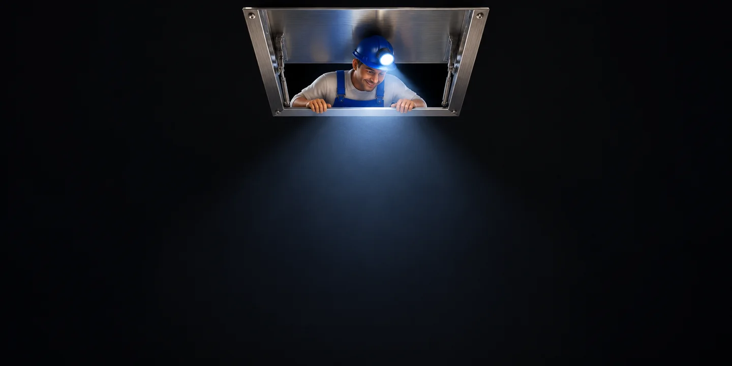 A miniature helper looks down through a metal ceiling hatch. His headlamp casts light toward the plan.